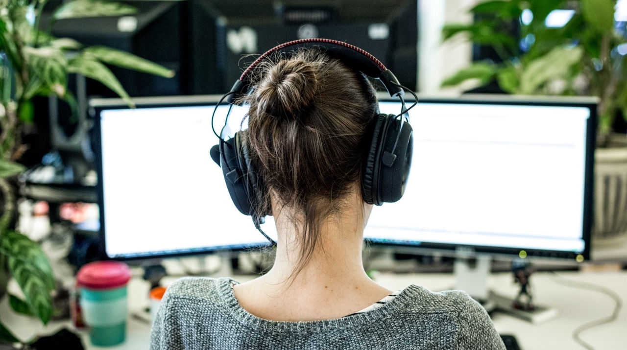 person sitting in front of a computer wearing headphones
